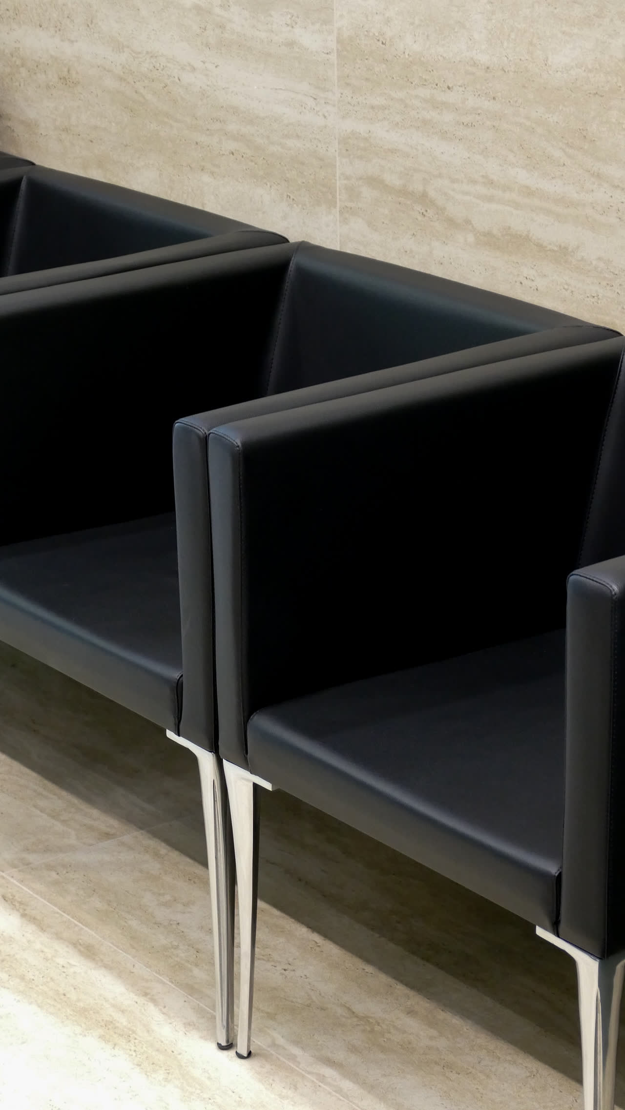 Poltroncine dell'area attesa su pavimento in travertino