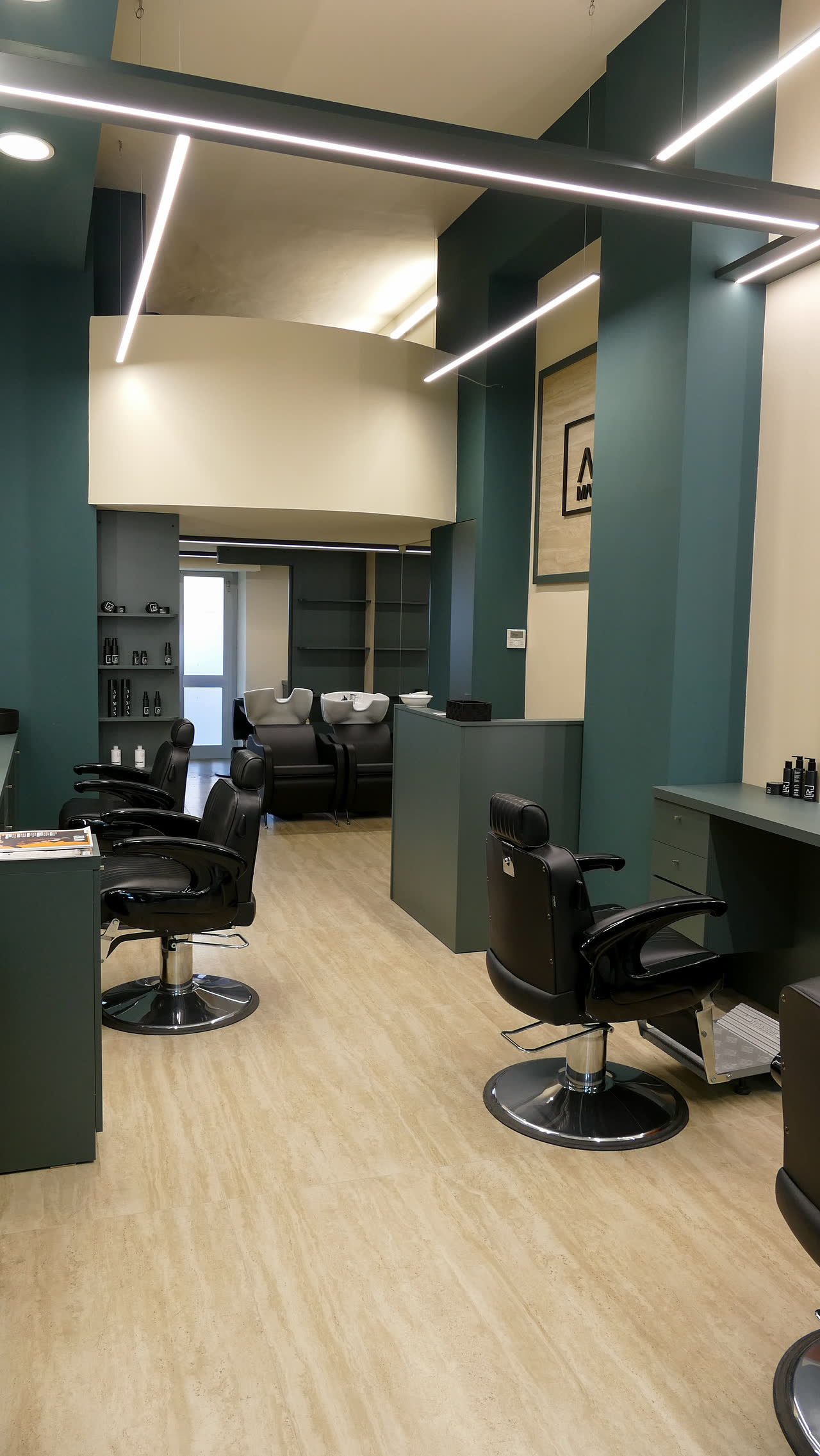 Interno del salone AFMAN con pareti verde petrolio e postazioni nere